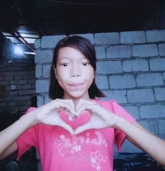 a girl making a heart with her hands