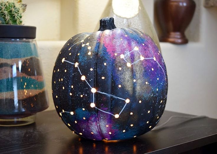 a painted pumpkin sitting on top of a table