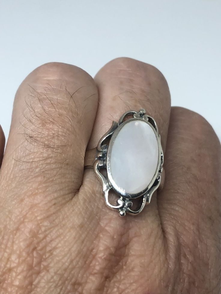 Lovely polished sterling silver has the look of Deco with a huge white Mother Of Pearl set in very detailed vintage filigree Size 7.75 We can size these with an additional $10-$20 fee for the jeweler All rings are shipped in a nice gift box. Check out our over a THOUSAND great reviews Engraving is $4 per letter and is not always perfect depending on the piece. It can take a few days if the jeweler is busy. This is payable to Paypal Judithsltd@gmail.com Classic White Oval Moonstone Ring, White Filigree Fine Jewelry, Vintage White Oval Cabochon Ring, White Fine Jewelry With Filigree Details, Classic White Cabochon Moonstone Ring, White Fine Jewelry With Filigree, Classic White Moonstone Ring In Sterling Silver, Fine White Filigree Jewelry, White Filigree Jewelry For Formal Occasions