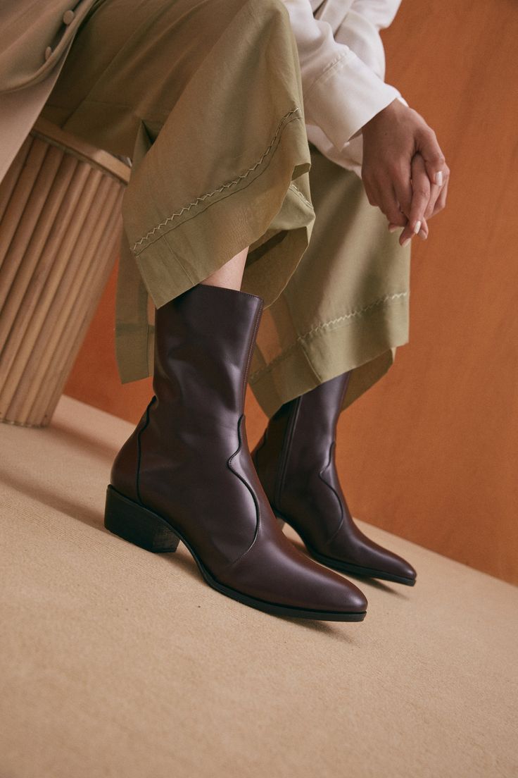 The Guada is a Western-inspired boot silhouette with stripped down detailing. An almond shaped toe, welted outsole and low stacked heel make this style feel feminine and powerful. A black base keeps the vibe modern and sleek. Featuring a mid-height shaft that extends to the low calf, this boot is designed to disappear under hems of cropped skirts and trousers without adding the unnecessary bulk of a taller shaft. The heel height makes this a great everyday style, while the toe shape dresses up y Boot Silhouette, Special Occasion Shoes, Wool Overcoat, Almond Shaped, Womens Summer Shoes, Sustainable Fashion Brands, Next Fashion, Western Boot, How To Make Shoes