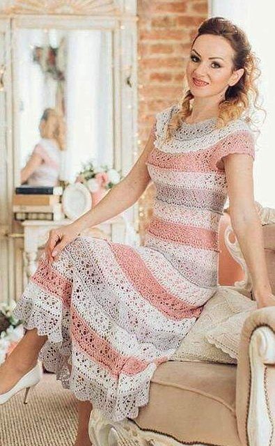 a woman sitting on top of a couch wearing a dress and smiling at the camera