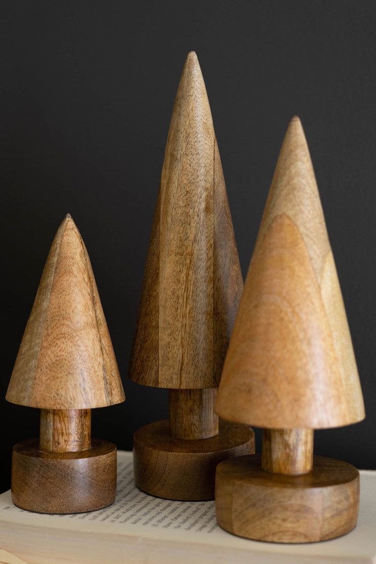 three wooden toy trees sitting on top of a table