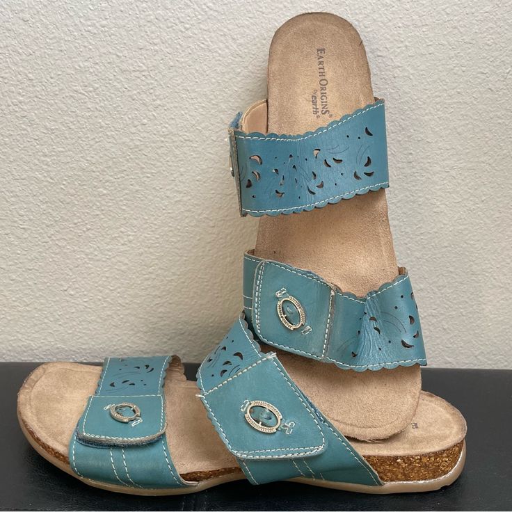 Earth Origins By Earth. Women’s Size 11 Wide. Like New (See Bottom Of Shoes). Soft Leather Upper. Two Straps. Slide On. Both Straps Are Adjustable Velcro. Cute Floral Cutout Design. Color Is Sort Of Mix Between Slate Blue And Turquoise Blue. Please Note, Although Unworn, The Footbed Fabric Has Become Separated In A Couple Spots Due To Storage. A Few Drops Of Glue Should Do The Trick. These Are A Comfort Brand Sandal That Retails For About $70.00. Light Blue Cushioned Sandals, Blue Sandals With Buckle Closure And Round Toe, Blue Round Toe Sandals With Buckle Closure, Blue Adjustable Sandals With Buckle Closure, Adjustable Blue Sandals With Buckle Closure, Comfortable Adjustable Blue Sandals, Blue Flat Heel Casual Sandals, Casual Blue Sandals With Flat Heel, Comfortable Blue Sandals With Removable Insole