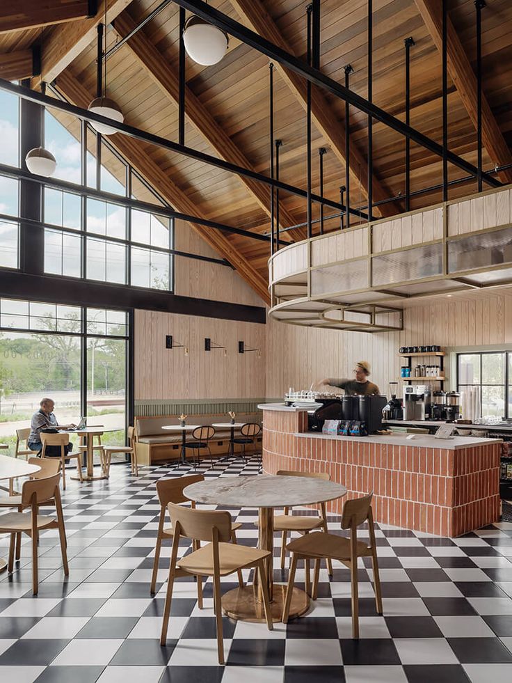 the interior of a restaurant with checkered flooring and wooden tables, chairs, and counters