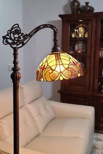 a lamp that is sitting on top of a table next to a white couch in a living room