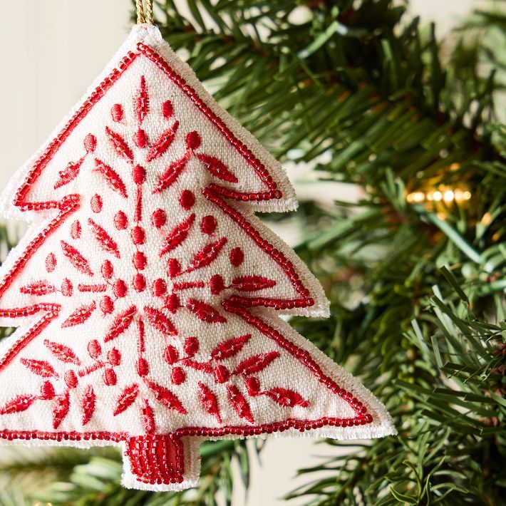 a red and white ornament hanging from a christmas tree