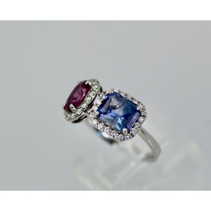 This is part of Chairish’s Fine Jewelry assortment.  18K Blue and Pink Sapphire Diamond Ring 3.28 carats  I just love this ring as I love the color of Blue and Pink Sapphires together. I considered making earrings to match one blue one pink Sapphires with a Diamond surround but if this sells then there is no need. This Blue and Pink Sapphire ring is beautiful with one (1) cushion blue Sapphire and one (1) oval Pink Sapphire. Both the Sapphires are transparent and have a Diamond surround size 6.5 Platinum Gemstones With Halo Setting Fine Jewelry, Platinum Gemstones With Halo Setting, Blue Brilliant Cut Gemstones For Formal Occasions, Formal Blue Brilliant Cut Gemstones, Luxury Blue Sapphire Platinum Ring, Blue Sapphire Gemstone Ring In Platinum, Platinum Blue Sapphire Gemstone Ring, White Gold Gemstones With Halo Setting Fine Jewelry, Luxury Blue Gemstones For Formal Occasions