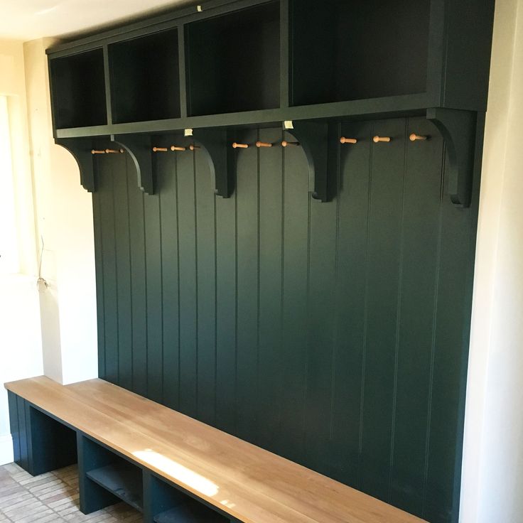 a wooden bench sitting in the middle of a room next to two black shelves with lights on them