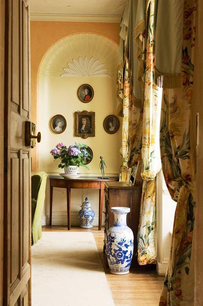 an open door leading to a hallway with vases and paintings on the wall