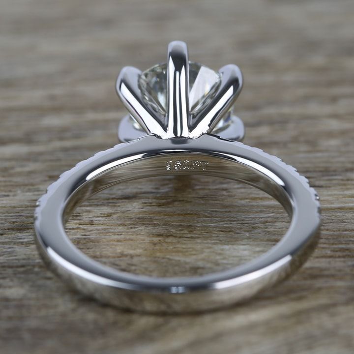 a close up view of a diamond ring on a wooden surface