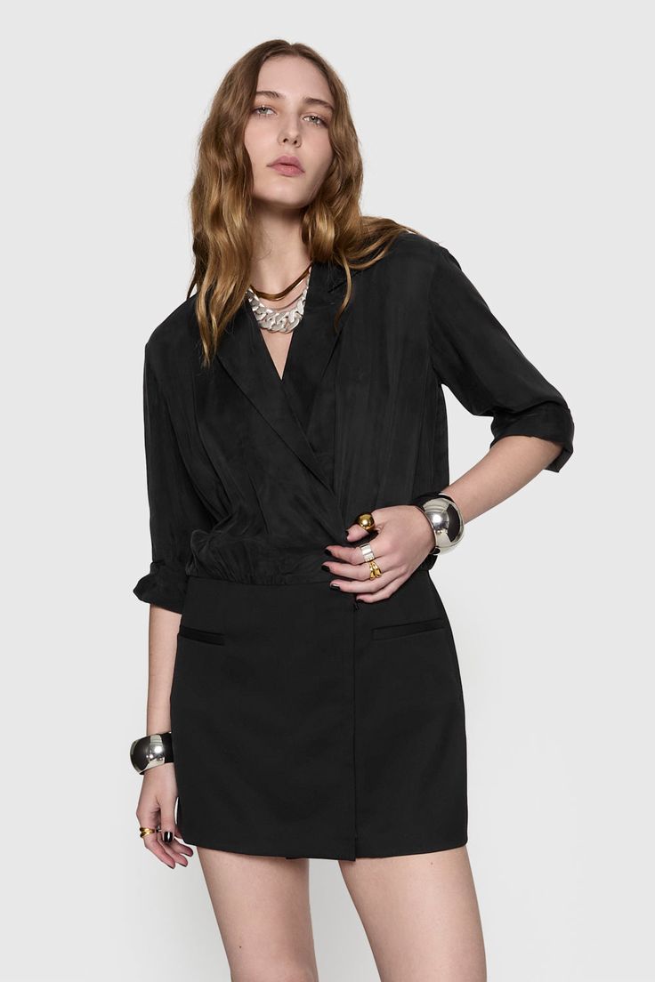 The McKenna Draped Mini Dress is a woven long sleeve dress featuring a combo skirt with a chic collar and lapel front. With welt pockets at the skirt and a wrap front opening with a zipper underneath, this dress is perfect for the woman who effortlessly combines classic elegance with a modern edge. | Rebecca Minkoff Mckenna Draped Mini Dress In Black - Size S