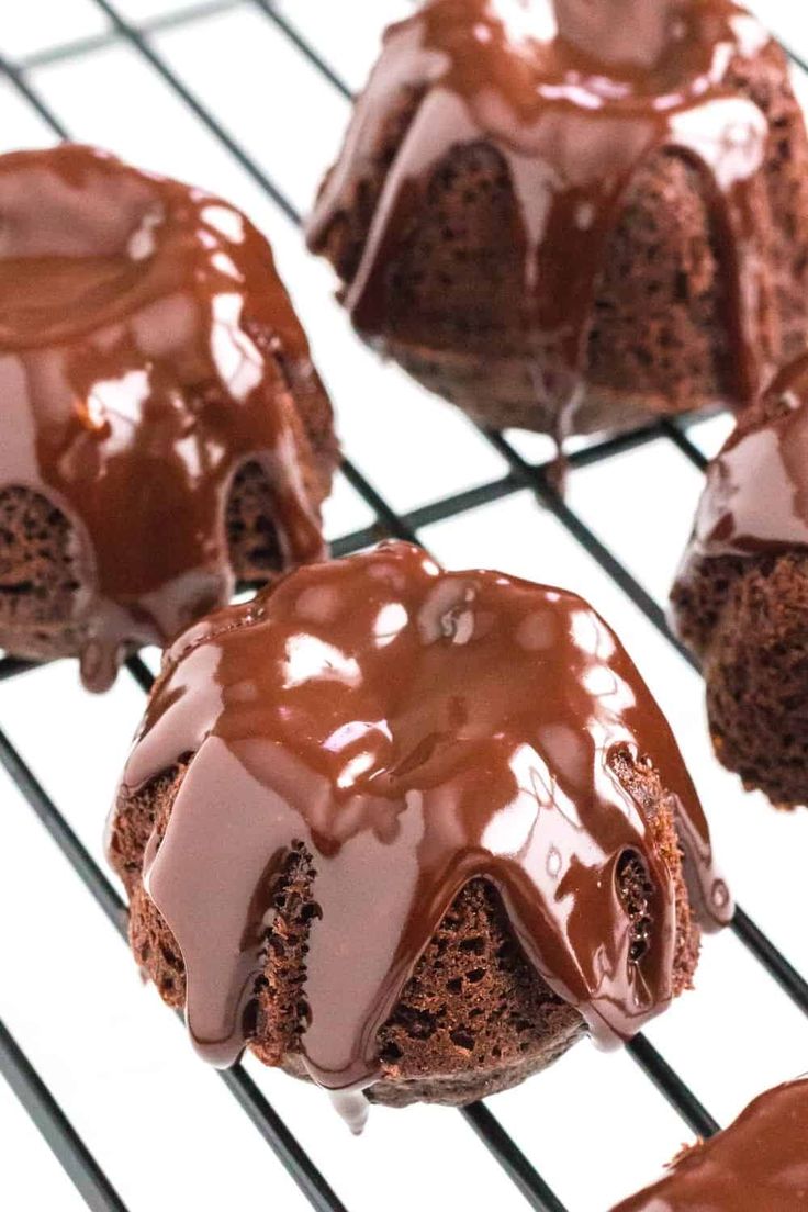 chocolate bundt cakes cooling on a rack with drizzled chocolate icing