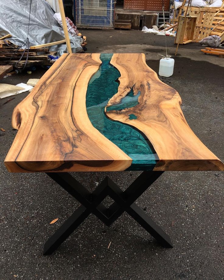 a table made out of wood and glass in the shape of a river or stream