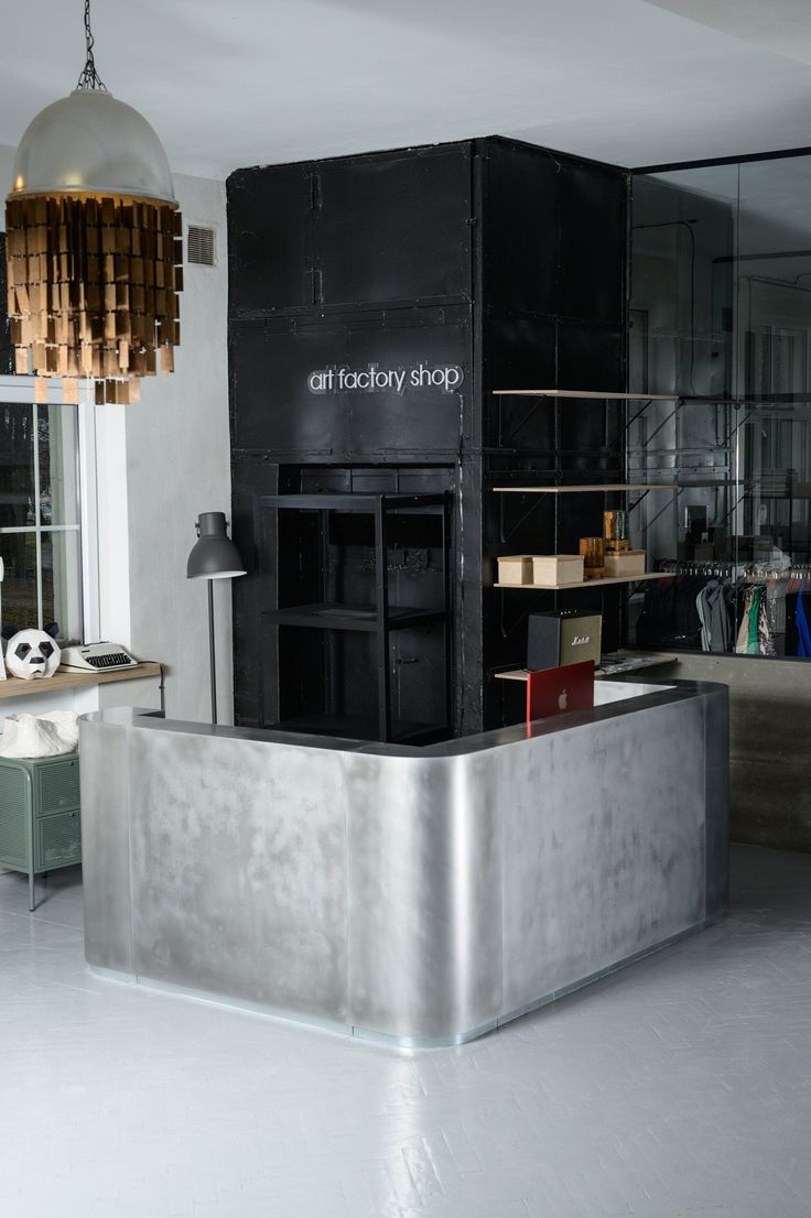 an empty room with a large metal counter in front of it and a lamp hanging from the ceiling