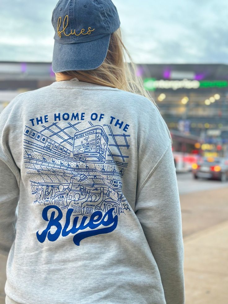 Extra soft, professionally screen printed St. Louis Hockey sweatshirt. These oatmeal heather sweatshirts feature a blue screen printed design on the front and back of the shirt.  Get the perfect gift for your favorite Blues fan with this vintage style hockey design. The back design features some special details only a true fan would recognize: a nod the towel guy, retired Blues numbers, Louie, Gloria, and more.  Fit: These are are true unisex sizing. Size up 1-2 sizes for an oversized look. See Throwback Cotton Sweatshirt With Screen Print, Relaxed Fit Sweatshirt With Screen Print For Fans, Throwback Fan Merchandise Cotton Sweatshirt, Casual Screen Print Sweatshirt For Fans, Casual Sweatshirt With Screen Print For Fans, Throwback Cotton Sweatshirt For Fan Merchandise, College Throwback Style Sweatshirt With Screen Print, Blue Pre-shrunk Sweatshirt For Streetwear, Blue Sweatshirt With Screen Print For Winter