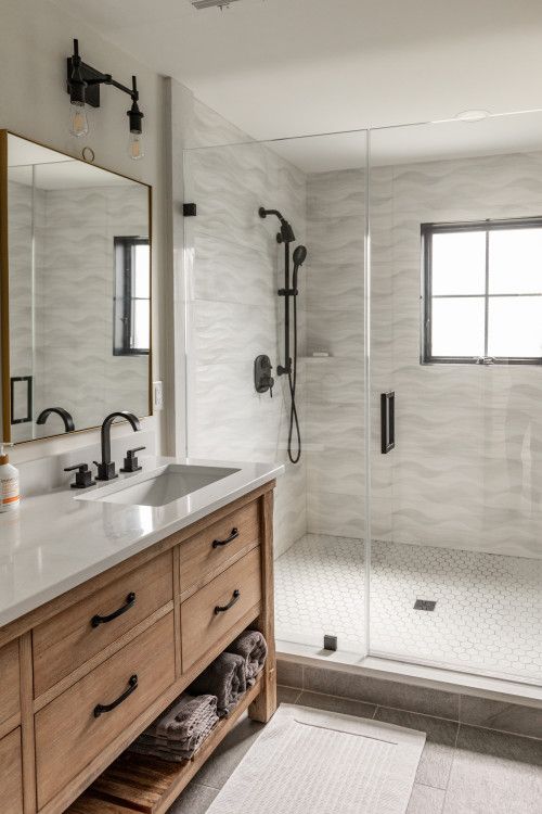 the bathroom is clean and ready to be used as a walk in shower with glass doors