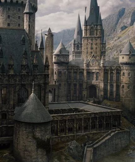 the hogwarts castle in harry potter's wizard land is shown with mountains in the background