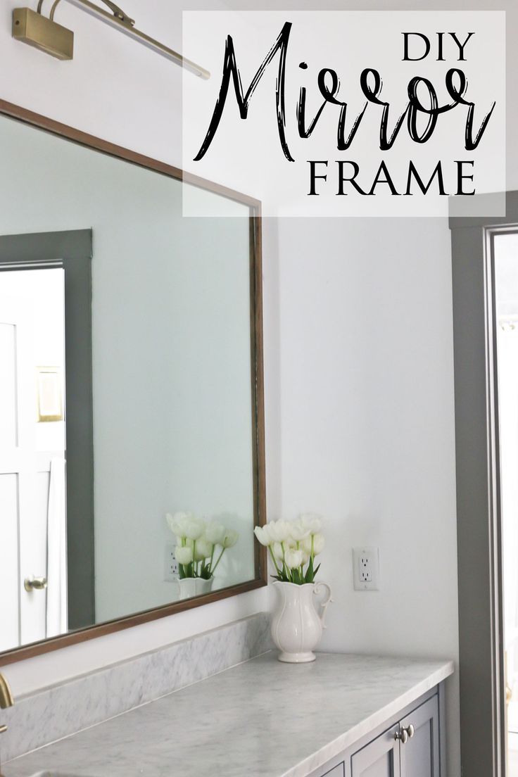 a bathroom with marble counter top and white flowers in vase on the sink area next to mirror