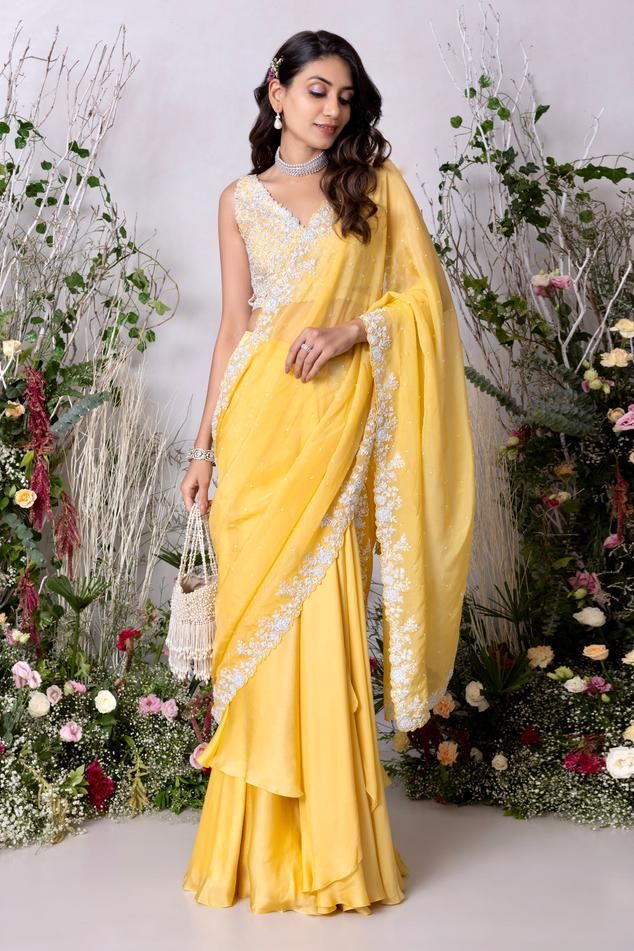 Yellow lehenga saree, accentuated with placement floral hand embroidery. Paired with a floral hand embroidered blouse.
Components: 2
Pattern: Hand Embroidery
Type Of Work: Floral, Beads, Sequins
Neckline: Deep V Neck
Sleeve Type: Sleeveless
Fabric: Satin Organza Blend, Viscose Organza
Color: Yellow
Other Details: 
Length:
Blouse: 14.5 inches
Lehenga Saree: 44.5 inches
Weight: 3 kgs
Attached inner lining
Note: The potli bag shown in the image is not for sale
Occasion: Sangeet - Aza Fashions Festive Draped Georgette Gown, Traditional Draped Wear With Resham Embroidery For Eid, Sleeveless Georgette Traditional Wear For Wedding, Navratri Draped Sets With Sheer Dupatta, Draped Georgette Dresses For Diwali, Wedding Gown With Zari Work And Draped Shape, Draped Wedding Gown With Zari Work, Wedding Gown With Draped Zari Work, Designer Wear Draped Sharara With Resham Embroidery