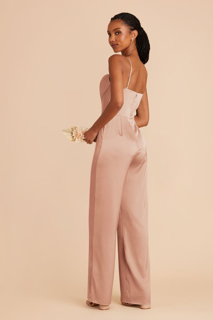 a woman wearing a pink jumpsuit and heels