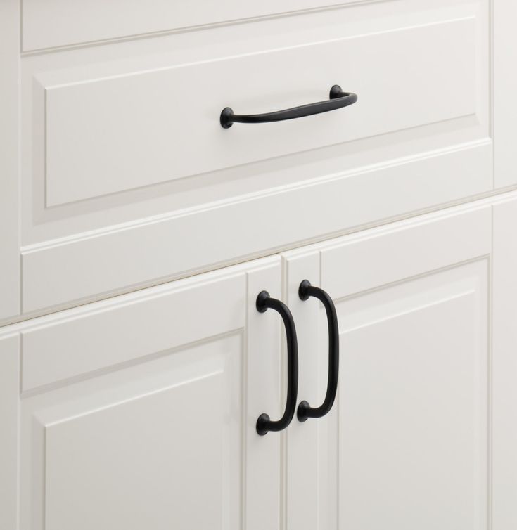 a kitchen cabinet with two black handles on it