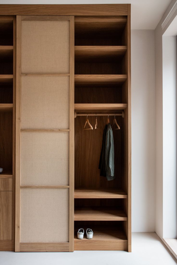 an open closet with clothes and shoes in it