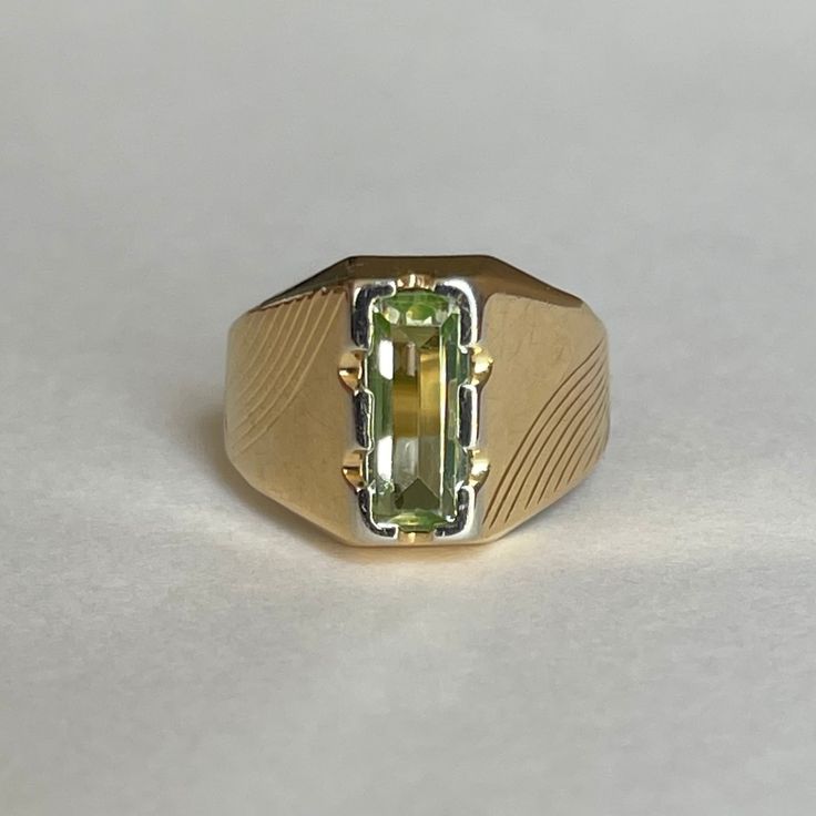 Mid Century Italian 18K Green Spinel Ring, Size 5.5, 3.5grams Size: 5.5 Weight: 3.5 grams Stone: Green Spinel Size Stone: ca. 10mm x 4mm   Number of Gemstones: 1 Cut: Emerald Bandwidth: ca 3.2mm at smallest point Markings:  Condition: Good preowned,  usage throughout -refer to pictures for condition.  All jewelry will be professionally cleaned before shipping and come in a beautiful little gift box. Returns accepted but are subjected to a 8% restock fee. Returns are only accepted for national orders. Formal Green Sapphire Ring With Vvs Clarity, Luxury Yellow Gold Peridot Rings, Luxury Yellow Gold Signet Ring With May Birthstone, Luxury Yellow Gold Signet Ring For May Birthstone, Yellow 14k Gold Emerald Cut Rings, Luxury Green 14k Gold Signet Ring, Modern Gold Emerald Ring With Center Stone, Yellow Gemstone Rings With Baguette Cut, Formal Polished May Birthstone Signet Ring