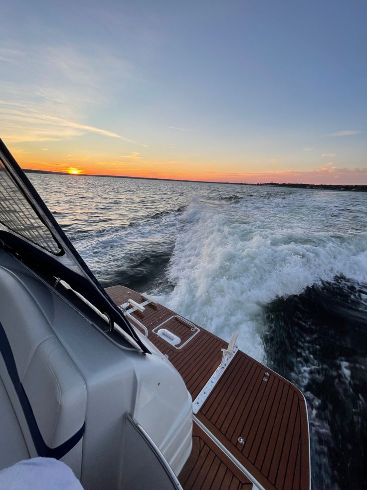 the sun is setting over the water from a boat in the open ocean with waves