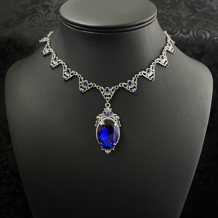 "This elegantly ornate necklace is made with antique silver tone centerpieces, featuring filigree and leaf details. Its mesmerizing design is accented with dazzling dark sapphire blue glass crystals with a large high quality faceted jewel hanging at its center.  Decorated portion is 8 1/2\" wide and 2 1/4\" tall in the very center.  Necklace length is adjustable with soldered stainless steel cable chain, lobster clasp and extender. If you would like a different length, please send us a message. If you don't see items with a color you want, feel free to ask about availability." Sapphire Vintage Necklace, Gothic Antique, Ornate Necklace, Medieval Necklace, Dark Sapphire, Victorian Wedding, Choker Pendant, Gothic Necklace, Gem Necklace