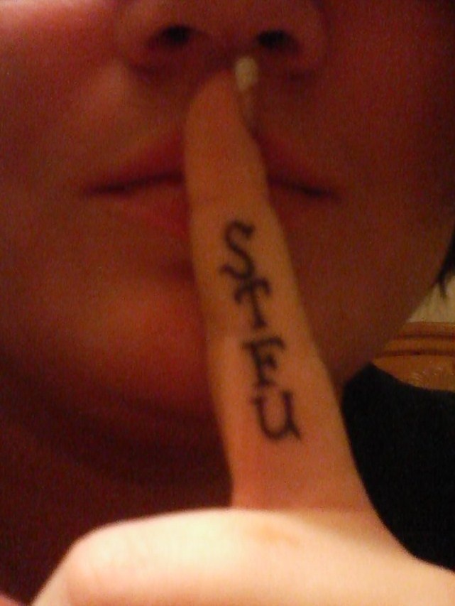 a woman is holding her finger up to her mouth with the word peace written on it