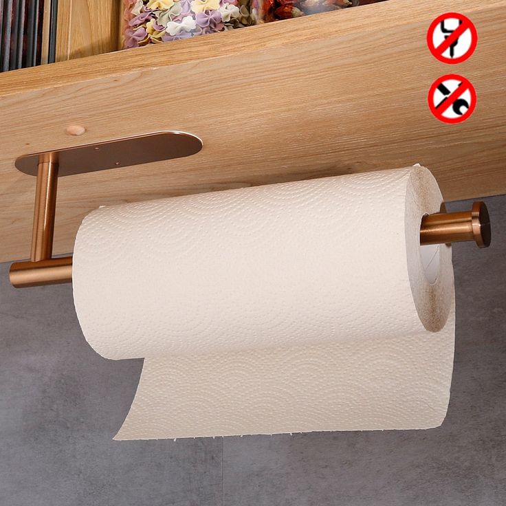 there is a roll of toilet paper hanging from the ceiling above a shelf with two red and white signs on it