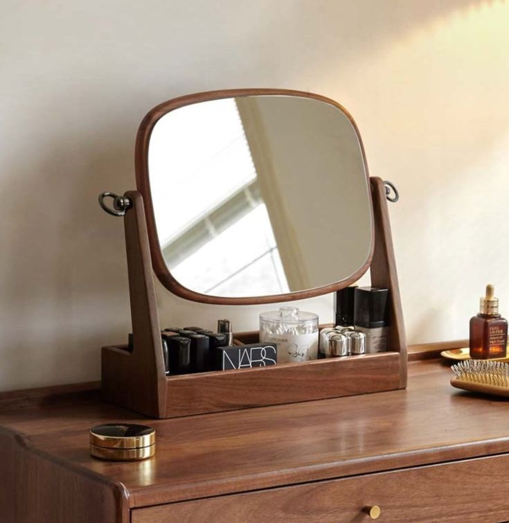 a wooden dresser with a mirror and other items on it