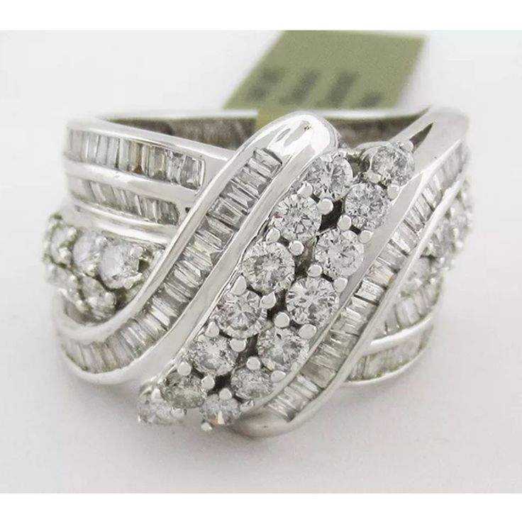 Karat: 14k White Gold Gemstones: 28 Genuine Round Diamonds - 0.07 Ct Each 72 Genuine Baguette Diamond - 0.02 Ct. Each Total Ct Weight : 3.40 Carats Diamonds Grades, Clarity Grade . . . Vs2 Color Grade . . . H Cut . . . Good Size 7 (Resizing Service Available If Needed) Net Weight : 7.9 Grams Type Of Setting : Prong/ Channel Shape Of Stone : Round & Baguette Resizing Service Available To Any Finger Size For A Low Cost Of $25.00 (Request This Service If Needed) Appraisal Available For A Low Cost O 14k White Gold Jewelry With Diamond White Baguette Diamonds, Luxury 14k White Gold Jewelry With Baguette Diamonds, White Baguette Cut Diamond Ring For Anniversary, White Round Rings With Baguette Diamonds, White Round Baguette Diamond Rings, White Baguette Diamond Rings, 14k White Gold Cluster Jewelry, 14k White Gold Baguette Diamond Jewelry, White Baguette Diamond Jewelry For Anniversary