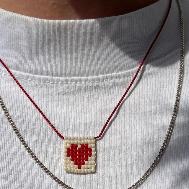 a man wearing a white t - shirt with a red heart on it's chest