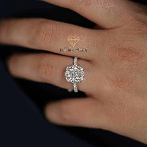 a woman's hand with a diamond ring on her left hand and the center stone is