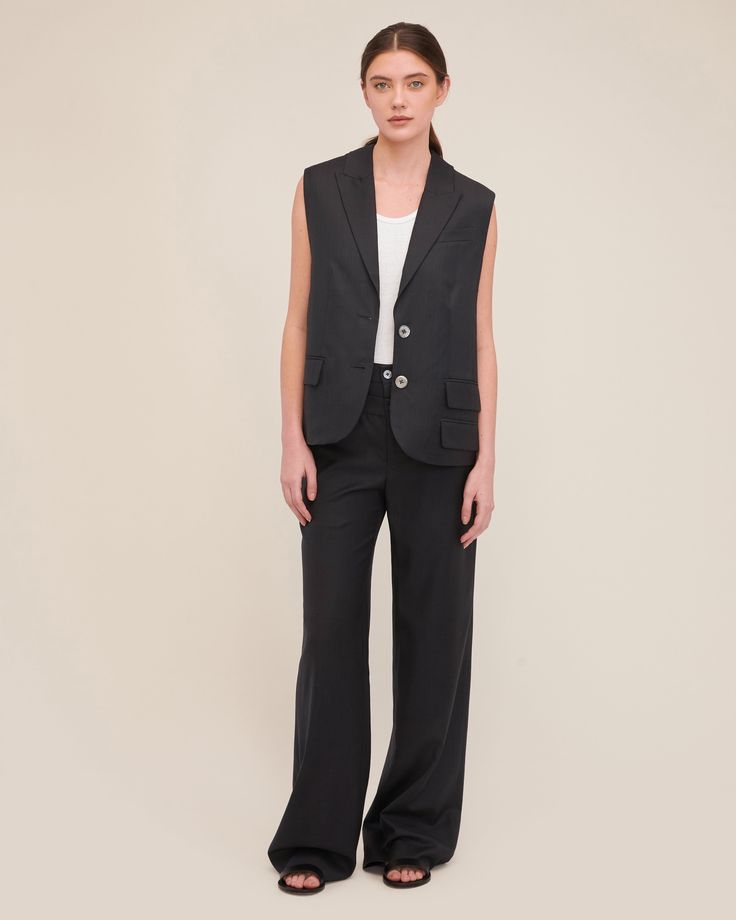 The Olivia is a modern take on the classic blazer vest. With its relaxed fit, dropped armhole and luxurious wool, this light suit vest lends itself to many styling choices. Layer over your favorite tank or button-up shirt or dare to wear her alone as a statement piece. For a polished yet edgy pairing, wear the Olivia with the Obie Asymmetrical Double Waist Trouser. Relaxed fit Notch collar with traditional blazer details Single breasted, button closure Sleeveless Dropped armholes Light shoulder Notch Lapel Suit With Vest For Work, Tailored Blazer With Vest For Office, Notch Lapel Vest With Hidden Button Closure For Work, Tailored Sleeveless Blazer With Hidden Button Closure, Workwear Vest With Notch Lapel And Hidden Buttons, Classic Sleeveless Office Blazer, Sleeveless Vest Suit For Workwear, Sleeveless Suit With Vest For Workwear, Chic Business Casual Vest With Hidden Button Closure