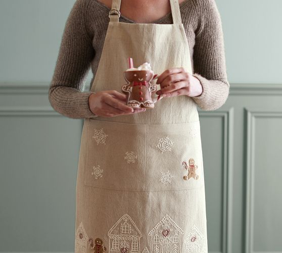 a woman in an apron holding a cup