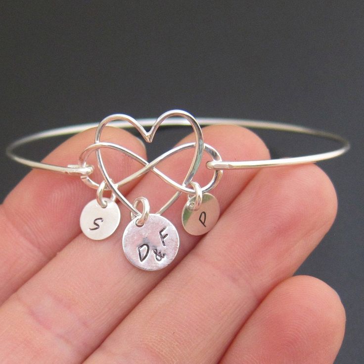 "Family Infinity Heart Bracelet - Personalized Mother's Day Gift Jewelry Choose infinity heart charm in sterling silver or 14k gold filled to be transformed into a personalized family bracelet with the initials of family members and bangle band in matching finish. Please mention initials in notes to seller during checkout. The first initial charm dangles from the heart in the middle. I can stamp parent's or couple's initials, mom's initial or guardian's initials, or grandparent's initials. I can Personalized Heart Pendant Bracelets For Anniversary, Personalized Adjustable Bracelet With Heart Pendant, Personalized Adjustable Heart Pendant Bracelets, Anniversary Charm Bangle Bracelet For Valentine's Day, Personalized Adjustable Heart Pendant Bracelet, Mother's Day Heart Bracelet With Charms As Personalized Gift, Heart Bracelet With Charms For Mother's Day, Anniversary Bangle Charm Bracelet For Valentine's Day, Personalized Heart Bracelet For Valentine's Day