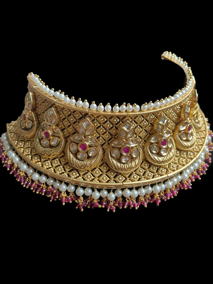 This elegant and gorgeous choker with matching earrings and tikka is perfect for the bold and beautiful bride and is handmade with traditional work of highest quality to give you the best look! It comes with matching earrings and tikka and can be worn as a semi bridal set as well. Heavy Kundan Lehenga For Reception, Bollywood Style Lehenga For Reception, Kundan Temple Jewelry Tikka For Reception, Kundan Temple Jewelry Bridal Necklace For Reception, Bollywood Kundan Bridal Accessories For Reception, Kundan Lehenga With Hand Set Details For Reception, Heavy Kundan Lehenga For Wedding, Hand Set Lehenga For Diwali Reception, Wedding Lehenga With Heavy Kundan Work