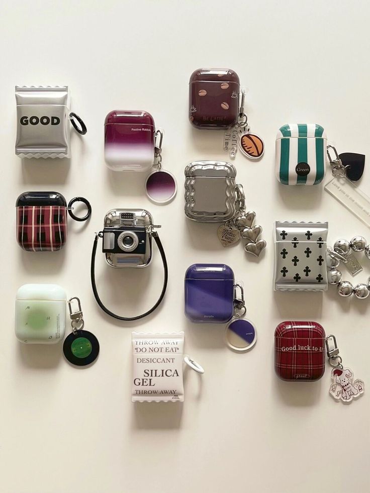 many different items are arranged on a white surface, including a camera and keychain