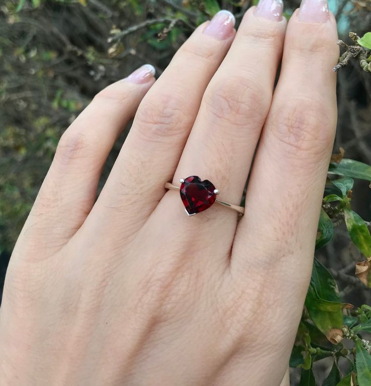 "A romantic Heart-Shaped genuine faceted Red Garnet prong set on a tapered band handcrafted in your choice of metal such as Silver, Rose Plated Silver, Gold Plated Silver. Add your Personalize touch by Engraving the Ring with a Memorable Message, Max 12 Letters.. This beauty makes a great Birthstone Ring for those January Birthday gals! Wrapped in a box ready for gift-giving.(r-265) Ring Info --------------------- *Genuine Heart-Shaped Garnet measures 8mm; Can be made with other stones *Silver, Heart Shaped Jewelry With Prong Setting For Gifts, Classic Red Heart Ring For Wedding, Red Heart Shaped Wedding Rings, Classic Solitaire Jewelry For Valentine's Day, Red Birthstone Ring For Valentine's Day Proposal, Classic Trillion Cut Rings For Gift, Classic Trillion Cut Rings As Gifts, Heart Cut Jewelry With Prong Setting For Gift, Red Heart Cut Rings For Wedding