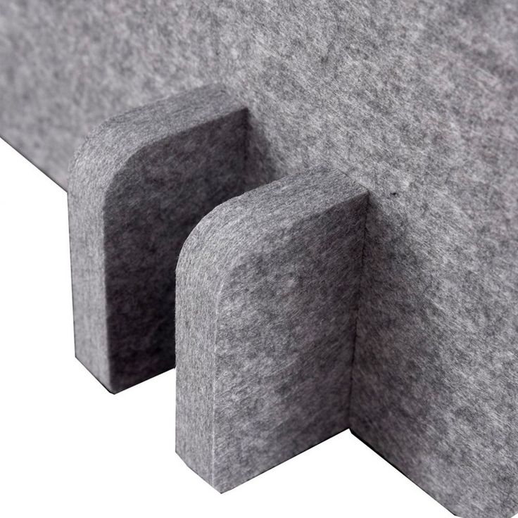 the corner section of a couch made out of grey felt with two holes in it