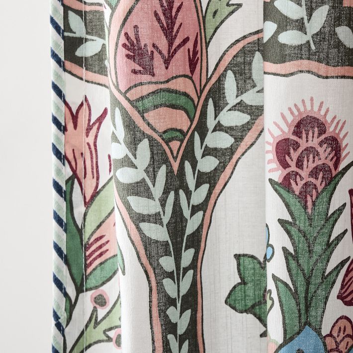 a close up view of a curtain with flowers and leaves printed on it, hanging from a rod