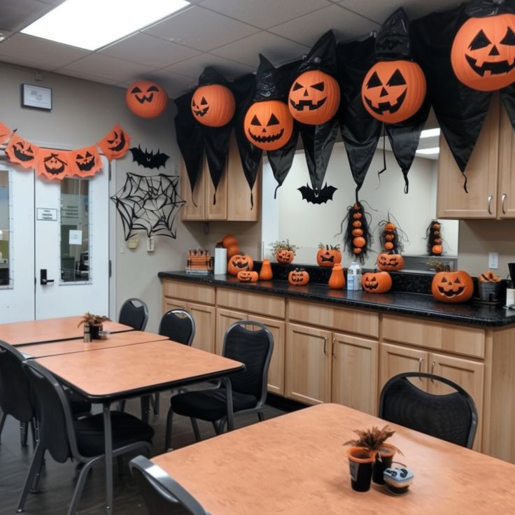 an office decorated for halloween with pumpkins on the wall and decorations hanging from the ceiling