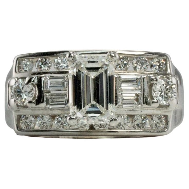 This gorgeous Vintage elegant ring is finely crafted in solid 14K White Gold and set with white and fiery genuine diamonds. The center emerald cut diamond is .50 carat. Four diamond baguettes .20 carats. Eighteen round brilliant cut diamonds total .44 carats. The diamonds are VS1 clarity and FG color for a grand total of (1.14cttw) The top of this genuine diamond ring measures 9mm North-South. The setting elevates 9mm high above the finger. This stylish ring is size 7.25 (can be resized) Total w Classic Emerald Ring With Diamond Accents And Octagon Shape, Classic Octagon Emerald Ring With Diamond Accents, Diamond White Emerald Ring With Diamond Accents In Platinum, Platinum Emerald Ring With Diamond Accents In Diamond White, Gia Certified Emerald Cut Diamond Ring In Diamond White, Octagon Emerald Ring With Diamond Accents, Octagon Brilliant Cut Diamond Ring, Timeless Platinum Emerald Cut Diamond Ring, Brilliant Cut Octagon Diamond Ring