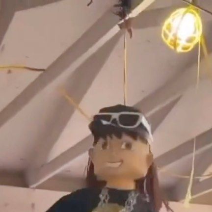 a stuffed doll hanging from a ceiling with lights