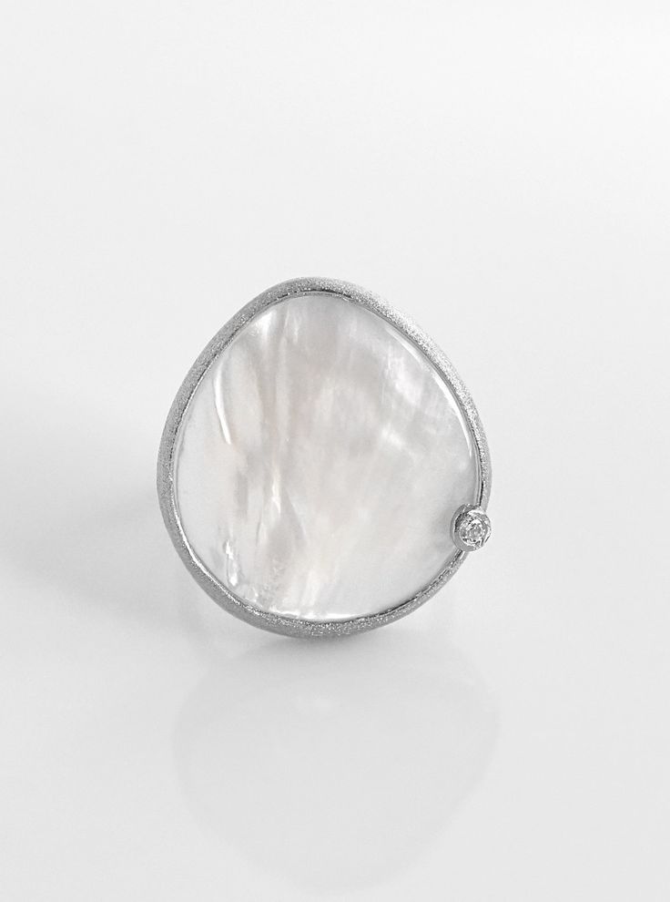 This exquisite 925 Mother of Pearl Ring is a timeless showstopper. With its teardrop shape, mother of pearl finish, and delicate crystal, it will add a tasteful touch of chic glamour to any ensemble. Crafted from luxurious 925 silver, its adjustable size ensures the perfect fit. Perfect for those special occasions. Luxury Mother Of Pearl Rings For Wedding, Luxury Mother Of Pearl Wedding Ring, Elegant Mother Of Pearl Round Rings, Elegant Oval Mother Of Pearl Ring, Elegant Round Mother Of Pearl Ring, Silver Teardrop Ring With Diamond Accents, Elegant Moonstone Ring As Gift, Elegant Moonstone Ring In White Gold Sterling Silver, Polished Mother Of Pearl Wedding Rings