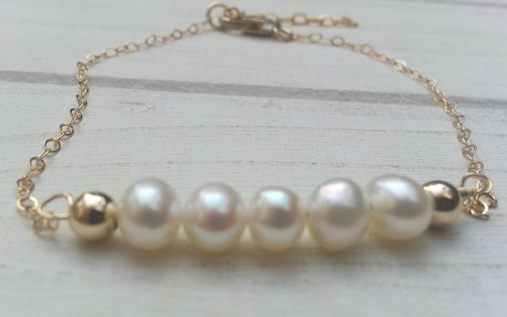 Delicate white pearls beaded bracelet on a goldfilled chain All the beads in the shop are natural stones. Pearl - contributes to a feeling of freshness, deep peace and purity. Good for the skin Pendant width: 1.2 inch / 3 cm  Bracelet length in the picture : 4.7 inch / 12 cm + 1.2 inch extension Total bracelet length: 5.9 inch + 1.2 extension You can choose the length in variations All items can be changed.  If you want to add,  remove, change a stone in this item, or if you want to make your own design mix and match from different parts of items in my shop just massage me and I'll do it gladly and with love All items comes in a gift box ready to give visit my shop: https://www.etsy.com/il-en/shop/TALYAJEWELRYDESIGN?ref=hdr_shop_menu Do you accept credit cards ? Yes, we do - I accept all c Elegant Pearl Bracelet With Beaded Chain, Gold Pearl Single Strand Beaded Bracelets, Pearl White Bracelet With Gold Beads As Gift, Pearl White Bracelet With Gold Beads For Gift, Gold Beaded Bracelets With Pearl Chain For Anniversary, Pearl Bracelet With Gold Beads As A Gift, Gift Pearl Bracelet With Gold Round Beads, Gold Beaded Pearl Bracelet As Gift, Gold Beaded Pearl Bracelet Gift