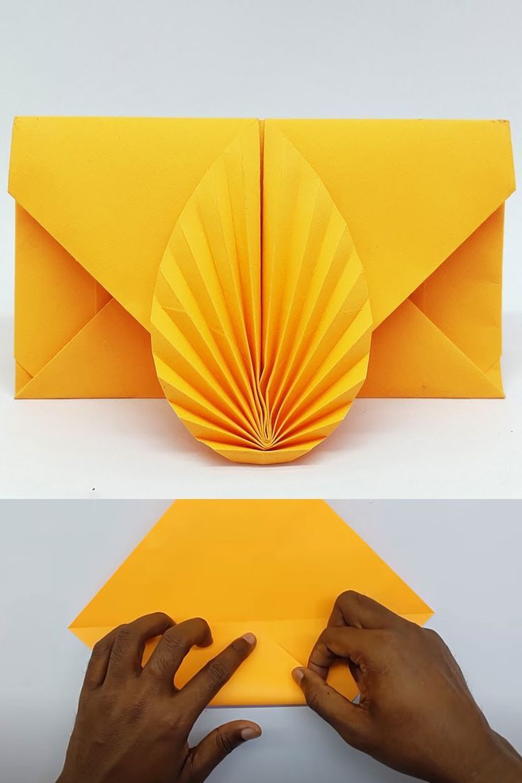 an origami envelope is being folded and placed on top of the other paper