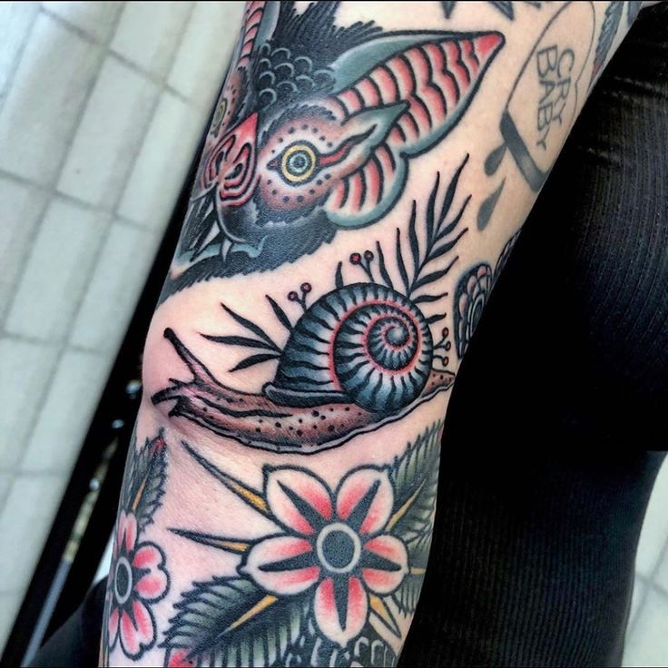 a person with a tattoo on their arm that has fish and flowers all over it